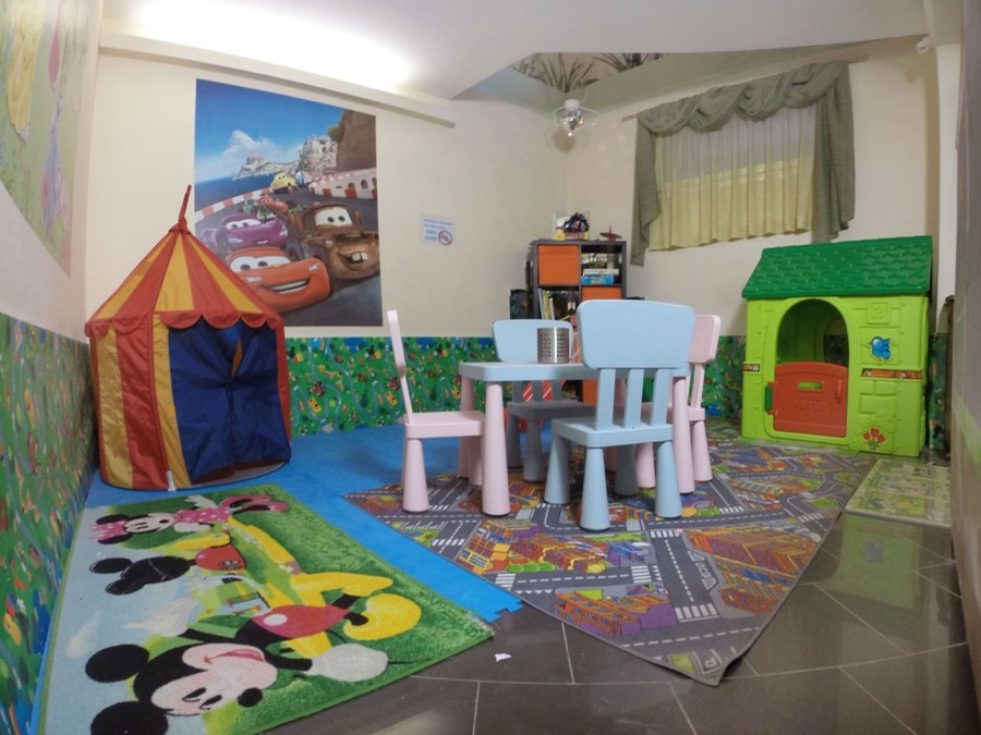 L'area giochi per bambini con tenda, tavolino, sedie e casetta