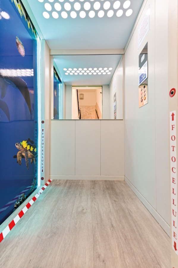 L'interno dell'ascensore dell'hotel, con la parete decorata a tema marino