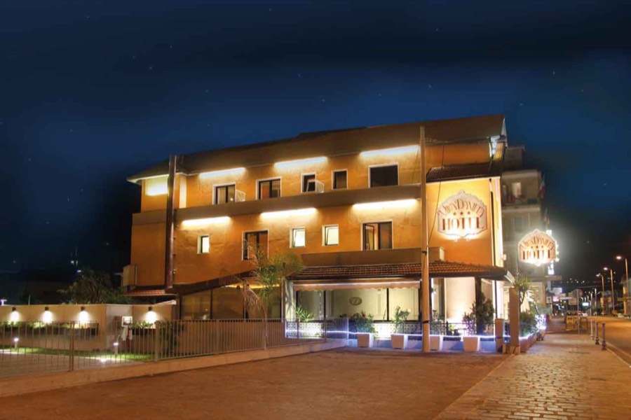La facciata illuminata dell'Hotel Villa Daniela di sera, sulla Via Aurelia